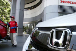 In this July 31, 2018, file photo, an employee of Honda Motor Co. cleans a Honda car displayed at its headquarters in Tokyo.