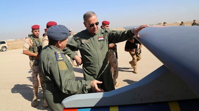 In this Oct. 10, 2015, file photo, Iraqi Defense Minister Khaled al-Obeidi, center, inspects a first Chinese drone to be used by the Iraqi Air Force at an airbase in Kut, Iraq.
