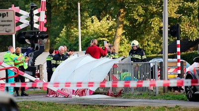 In a Thursday Sept. 20, 2018 file image from video, emergency services attend the scene after a train collided with a cargo bike, at a railway crossing point in the town of Oss, 100 kilometers southeast of Amsterdam, Netherlands.