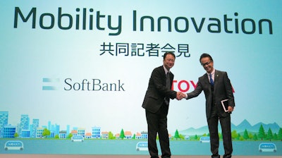 Representative Director and CTO of SoftBank Corp. Junichi Miyakawa, left and Executive Vice President of Toyota Motor Corporation Shigeki Tomoyama, right, shake hands during a press conference in Tokyo Thursday, Oct. 4, 2018.