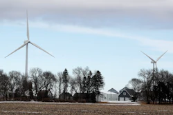 In this Feb. 2, 2018 file photo, wind turbines stand over a farmhouse near Northwood, Iowa.