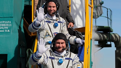 U.S. astronaut Nick Hague, right, and Russian cosmonaut Alexey Ovchinin, crew members of the mission to the International Space Station wave as they board the rocket prior to the launch of Soyuz-FG rocket at the Russian leased Baikonur cosmodrome, Kazakhstan, Thursday, Oct. 11, 2018.
