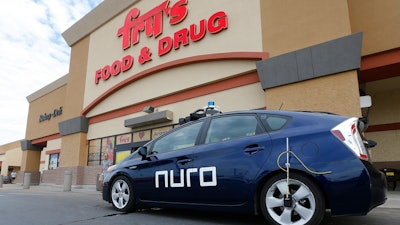 This Aug. 16, 2018, file photo shows a self-driving Nuro vehicle parked outside a Fry's supermarket, which is owned by Kroger, as part of a pilot program for grocery deliveries in Scottsdale, Ariz.