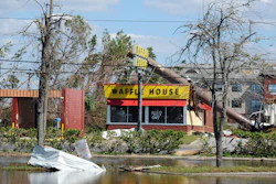In this Sunday, Oct. 14, 2018, photo, a billboard lies atop a Waffle House restaurant after being knocked down by Hurricane Michael, in Panama City, Fla.
