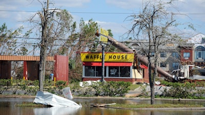 In this Sunday, Oct. 14, 2018, photo, a billboard lies atop a Waffle House restaurant after being knocked down by Hurricane Michael, in Panama City, Fla.