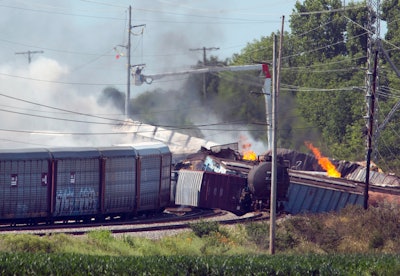 In this June 18, 2018, file photo, workers cut power to lines surrounding derailed CSX train cars as they continue to burn the morning after an explosion of a propane tank in Princeton, Ind.