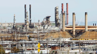This March 9, 2010, file photo shows a tanker truck passing the Chevron oil refinery in Richmond, Calif.