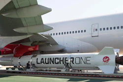 In this Thursday, Oct. 25, 2018, photo released by Virgin Orbit, a completed LauncherOne rocket hangs from the wing of Cosmic Girl, a special Boeing 747 aircraft that is used as the rocket's 'flying launch pad,' at the Long Beach Airport in Long Beach, Calif.