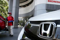 In this July 31, 2018, file photo, an employee of Honda Motor Co. cleans a Honda car displayed at its headquarters in Tokyo.