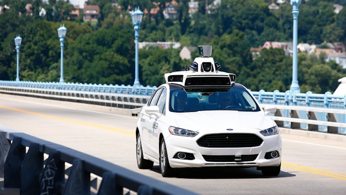 Uber employees testing a self-driving Ford Fusion in Pittsburgh.