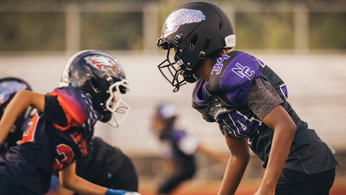 In this photo provided by VICIS, youth football players wear the company's new youth helmets during a helmet test-fitting and practice in Seattle.