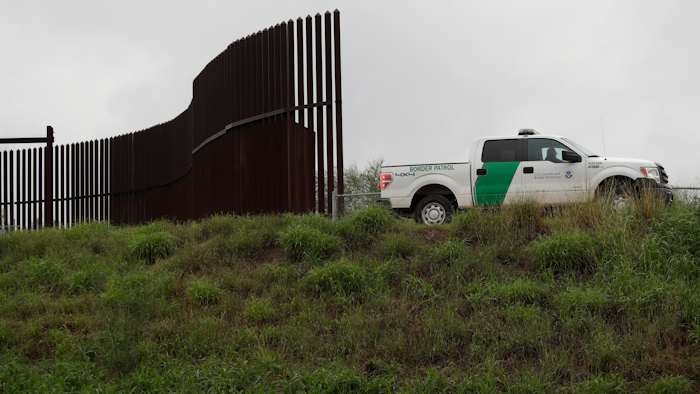 This Nov. 13, 2016, file photo shows a U.S. Customs and Border Patrol agent passes along a section of border wall in Hidalgo, Texas.