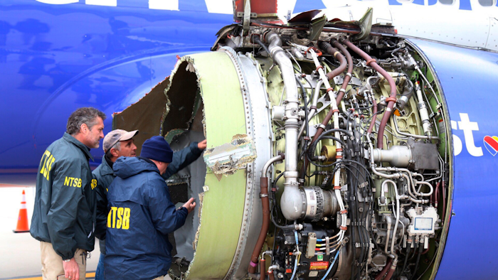 In this April 17, 2018, file photo, NTSB investigators examine damage to the engine of the Southwest Airlines plane that made an emergency landing at Philadelphia International Airport.