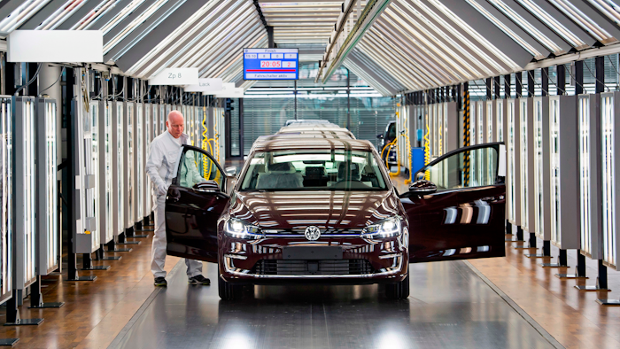 In this March 5, 2018 file photo, Roland Schulz makes the final check of an e-Golf electric car in Dresden, Germany.