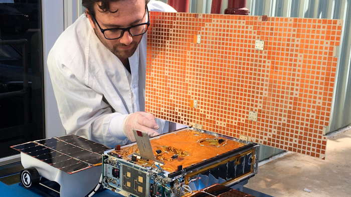 In this undated photo, engineer Joel Steinkraus uses sunlight to test the solar arrays on one of the Mars Cube One project in Pasadena, Calif.