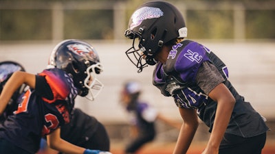 In this photo provided by VICIS, youth football players wear the company's new youth helmets during a helmet test-fitting and practice in Seattle.