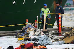 Port officials stand near debris from Lion Air Flight 610 that crashed into Java Sea, at Tanjung Priok Port in Jakarta, Indonesia, Friday, Nov. 2, 2018.