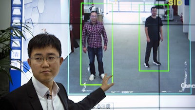 In this Oct. 31, 2018, photo, Huang Yongzhen, CEO of Watrix, demonstrates the use of his firm's gait recognition software at his company's offices in Beijing.