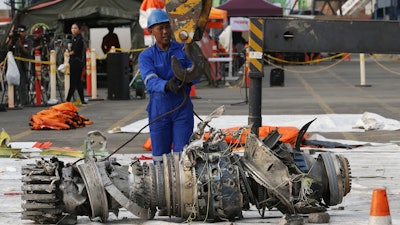 Officials move an engine recovered from the crashed Lion Air jet for further investigation in Jakarta, Indonesia, Sunday, Nov. 4, 2018.