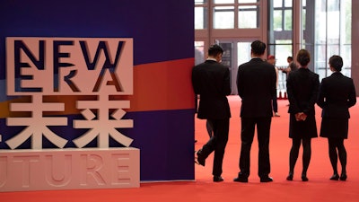 Workers wait for attendees to arrive at the China International Import Expo held in Shanghai, Monday, Nov. 5, 2018.