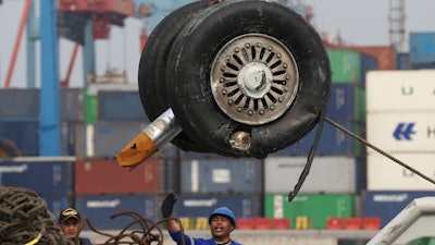 In this Saturday, Nov. 3, 2018, file photo, a crane moves a pair of wheels recovered from the Lion Air jet that crashed into the Java Sea for further investigation at Tanjung Priok Port in Jakarta.