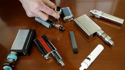 In this Tuesday, April 10, 2018, file photo, a high school principal displays vaping devices confiscated from students.