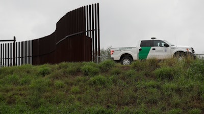 This Nov. 13, 2016, file photo shows a U.S. Customs and Border Patrol agent passes along a section of border wall in Hidalgo, Texas.
