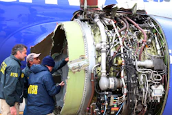 In this April 17, 2018, file photo, NTSB investigators examine damage to the engine of the Southwest Airlines plane that made an emergency landing at Philadelphia International Airport.