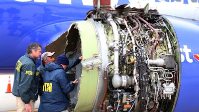 In this April 17, 2018, file photo, NTSB investigators examine damage to the engine of the Southwest Airlines plane that made an emergency landing at Philadelphia International Airport.