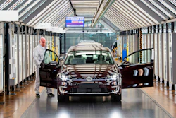 In this March 5, 2018 file photo, Roland Schulz makes the final check of an e-Golf electric car in Dresden, Germany.