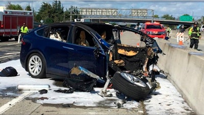 In this March 23, 2018 file photo, emergency personnel work a the scene where a Tesla electric SUV crashed into a barrier on U.S. Highway 101 in Mountain View, Calif.