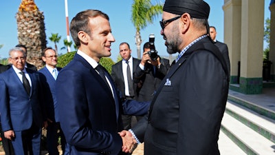 French President Emmanuel Macron, left, is welcomed by Moroccan King Mohammed VI at Tangiers' airport, Morocco, Thursday, Nov. 15, 2018.