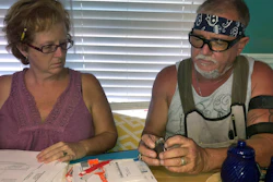 In this Oct. 31 2018 photo, George and Brenda Davis look at his nerve stimulator and medical documents at their home in Milton, Fla.