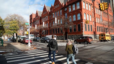 People cross the street next to the MOMA PS1 art museum in Long Island City, near the site for a proposed Amazon headquarters.