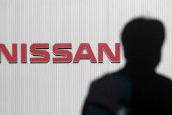 A man walks past the logo of Nissan Motor Co. in Yokohama Wednesday, Nov. 21, 2018.