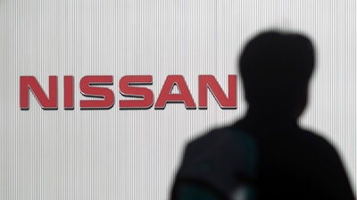 A man walks past the logo of Nissan Motor Co. in Yokohama Wednesday, Nov. 21, 2018.