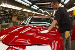 In this June 10, 2011, file photo, a worker checks the paint on a Camaro at the GM factory in Oshawa, Ontario.
