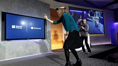 In this Jan. 21, 2015, file photo, Microsoft's Lorraine Bardeen demonstrates the HoloLens headset at the company's headquarters in Redmond, Wash.