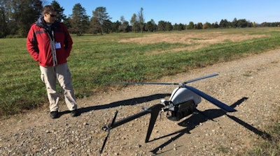 In this Oct. 17, 2017 photo, Nick Brown, a drone pilot for Pulse Aerospace of Lawrence, Kan., stands beside a Pulse Vapor unmanned aircraft at Griffiss International Airport in Rome, N.Y.