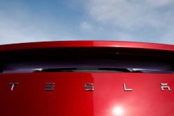 In this April 15, 2018, file photo, the sun shines off the rear deck of a roadster on a Tesla dealer's lot in the south Denver suburb of Littleton, Colo.