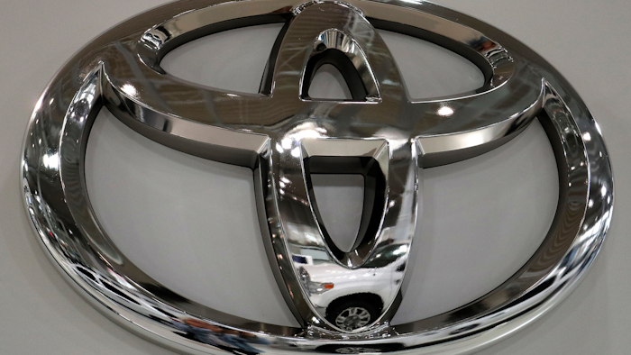 In this May 10, 2017, file photo a Toyota Land Cruiser is reflected on the emblem of Toyota Motor Corp. at a showroom in Tokyo.