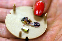 In this July 12, 2004, file photo, a woman holds a hearing aid that uses artificial intelligence in Somerset, N.J.