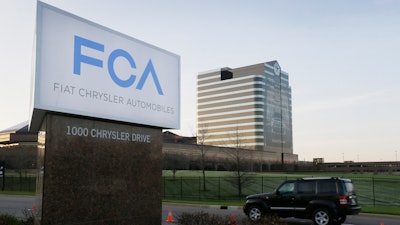 In this May 6, 2014, file photo, a vehicle moves past a sign outside Fiat Chrysler Automobiles world headquarters in Auburn Hills, Mich.