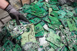 In this photo taken on July 13, 2018, a worker throws components of electronic elements into a bin at the Out Of Use company warehouse in Beringen, Belgium.