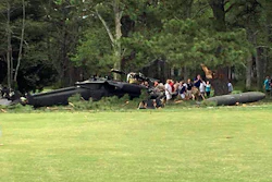In this Monday, April 17, 2017 file photo, people examine an Army UH-60 Black Hawk helicopter after it crashed at the Breton Bay Golf and Country Club in Leonardtown, Md.