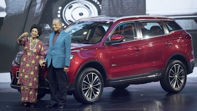 Malaysia Prime Minister Mahathir Mohamad, right, poses with his wife Siti Hasmah during the launch of Proton's new SUV in Kuala Lumpur.
