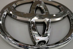 In this May 10, 2017, file photo a Toyota Land Cruiser is reflected on the emblem of Toyota Motor Corp. at a showroom in Tokyo.