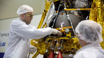 Yonatan Winetraub inserts a time capsule into the SpaceIL lunar module during a press tour of their facility near Tel Aviv, Monday, Dec. 17, 2018.