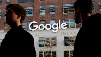 In this Dec. 4, 2017, file photo, people walk by Google offices in New York.