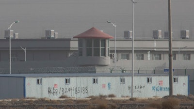 In this Monday, Dec. 3, 2018, photo, a guard tower and barbed wire fences are seen around a facility in the Kunshan Industrial Park in western China's Xinjiang region.